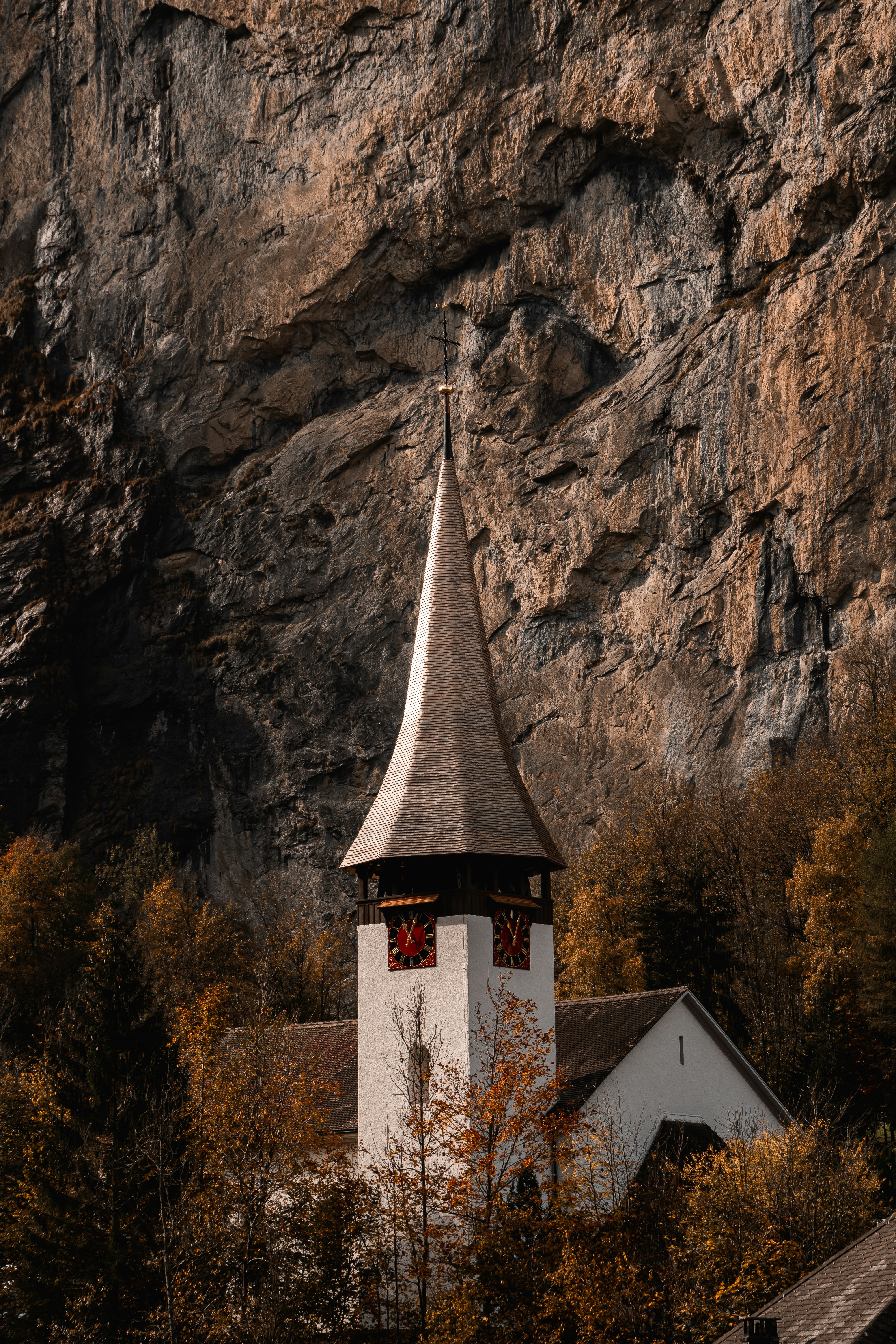 white and brown concrete church near brown and green trees during daytime